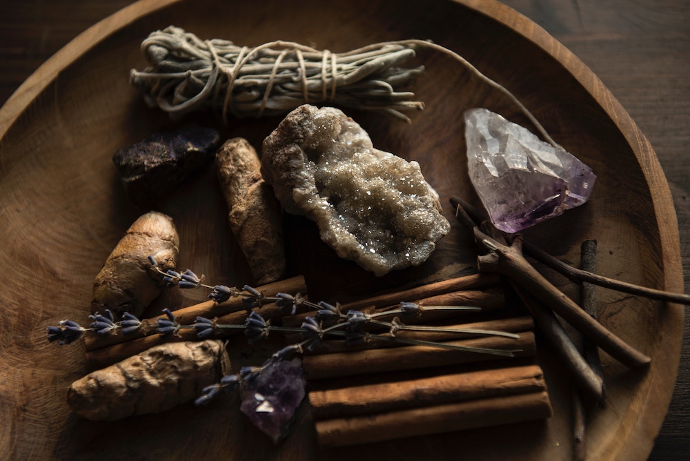 Crytals and sticks and flowers in a bowl